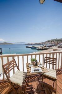 a table and chairs on a balcony with a view of a beach at Spitakia in Halki