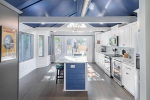 a kitchen with white cabinets and a blue ceiling at Folly Vacation Beautiful Beach Cottage 209-A in Folly Beach