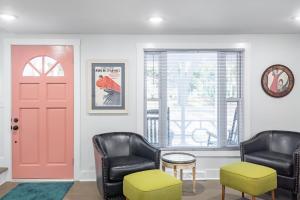 a waiting room with two chairs and a red door at Folly Vacation Beautiful Beach Cottage 209-A in Folly Beach