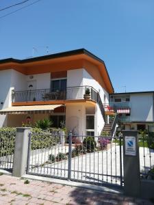 une maison avec une clôture devant elle dans l'établissement Cepele House, à Lignano Sabbiadoro