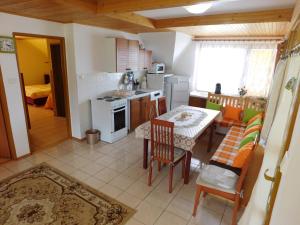 Apartmany Tania في Závažná Poruba: مطبخ وغرفة طعام مع طاولة وكراسي