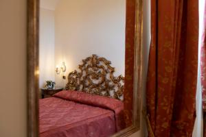 Amalfi Old Square room & apartments في أمالفي: مرآة تعكس سرير في غرفة النوم