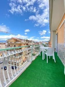 a balcony with green flooring and tables and chairs at Relais Bellavista B&B in Casalnuovo di Napoli