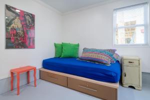 Schlafzimmer mit einem Bett mit blauer Bettwäsche und einem Tisch in der Unterkunft Folly Vacation Laid Back Casual Beach Bungalow 209-B in Folly Beach