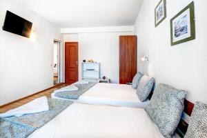 a bedroom with two beds and a tv on the wall at Guest House Zara in Primorsko