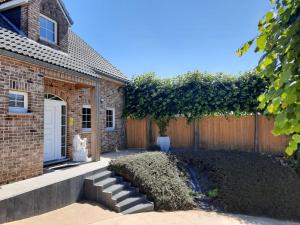 een stenen huis met een hek en een tuin bij Holiday Home Mooi - Voeren in Voeren