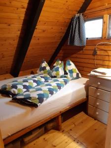 ein Schlafzimmer mit einem Bett in einer Holzhütte in der Unterkunft Pfahlbau Rust Robinsonhütte in Rust