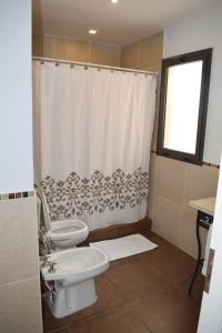 a bathroom with a toilet and a shower curtain at BELLA VISTA - CAFAYATE in Cafayate +25 photos