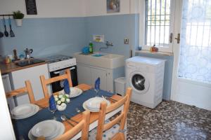 een keuken met een tafel en een wasmachine bij Dimora in collina in Monopoli