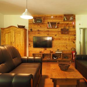 ein Wohnzimmer mit einem Ledersofa und einem Flachbild-TV in der Unterkunft APARTMAJI GOSPOUD SRMAK in Murska Sobota