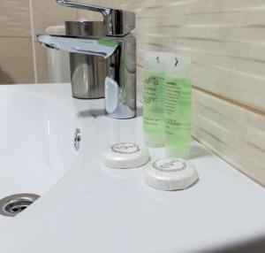 a sink with two tubes ofodorizers on a counter at Resita Residence in Reşiţa