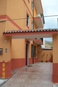 a building with orange and yellow walls and a courtyard at B&B Mediterraneo in Torre Melissa