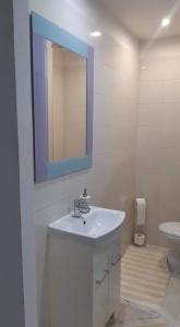 科馬爾諾的住宿－Szoba konyha lakas，一间带水槽、镜子和卫生间的浴室