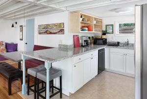 a kitchen with white cabinets and a counter with stools at Folly Vacation 305 E Erie Fantastic Location in Folly Beach