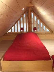 a bedroom with a red bed in an attic at APPT T2 PROCHE PLAGE in Plouharnel