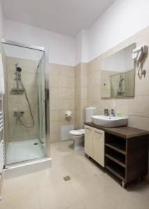 een badkamer met een douche, een wastafel en een toilet bij Resita Residence in Reşiţa