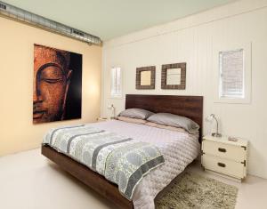 a bedroom with a bed and a painting on the wall at Folly Vacation 620 apartment w/bonus room, one block to the beach & pet friendly in Folly Beach