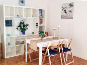 une salle à manger avec une table et des chaises blanches dans l'établissement Av. 1º de Maio, à Costa da Caparica 21 autres photos