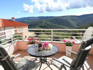 a table on a balcony with a view of mountains at Lovely apartment Branko Rabac with balcony and parking in Rabac