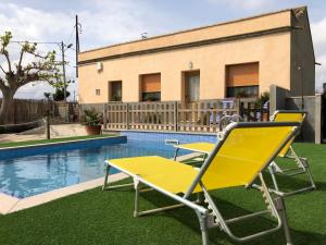 a group of chairs sitting next to a pool at Casa Los Hortets in Deltebre
