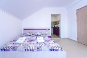 a large bed in a white room with at Vila Jun in Eforie Nord