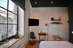 a bedroom with a bed and a desk and a window at Urban Nest in Huy