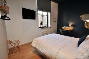 a bedroom with a bed and a window and a desk at Urban Nest in Huy