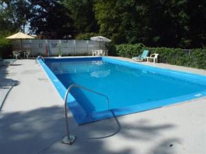 a swimming pool with a blue slide in a yard at Yankee Trail Motel in Holderness