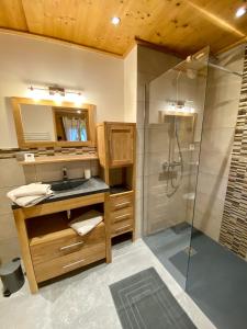 uma casa de banho com um lavatório e um chuveiro em Chalet luxe L'HIBISCUS em Samoëns