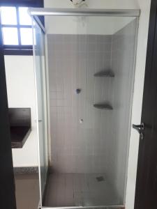 a shower with a glass door in a bathroom at Pousada do sol Meaipe in Guarapari