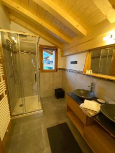 ein Bad mit einer Dusche und einem Waschbecken in der Unterkunft Chalet luxe L'HIBISCUS in Samoëns