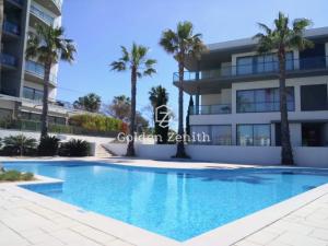 un edificio con piscina e palme di Cavalo Preto Luxury Beach Apartment by Golden Zenith a Quarteira