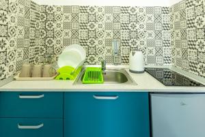 a kitchen with blue cabinets and a sink at Vila Jun in Eforie Nord +72 photos