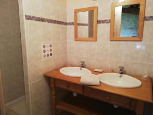a bathroom with two sinks and two mirrors at Les Chenets in Chenay