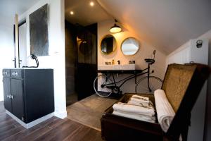 a bathroom with a sink and a couch with a mirror at La Petite Valise in Ploudalmézeau