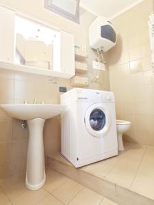 uma casa de banho com uma máquina de lavar roupa e um lavatório em La Torre - Frontemare - Immobil Relax em Lido di Jesolo