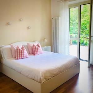 a bedroom with a bed with pink pillows on it at Locanda Rabaya' in Barbaresco