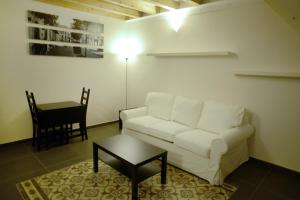 a living room with a white couch and a table at B&B Thule in Caltanissetta