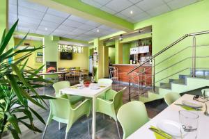 a restaurant with green walls and tables and chairs at Guest House Zara in Primorsko +13 photos
