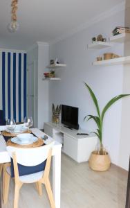 a white living room with a table and a dining room at Atlantic Getaway - T1 100 m to the Waves in Buarcos