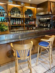 a bar with two chairs and a counter at Hôtel Bel'Air in Jausiers
