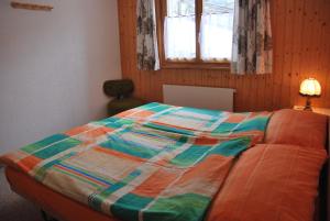 a bed with a colorful comforter in a bedroom at Ferienwohnung Bürchen in Bürchen