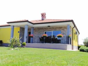 a small yellow house with a black fence at Holiday house ANITA in Umag