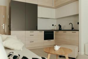 a kitchen with a couch and a table in a room at APARTAMENT Marina Port in Wrocław