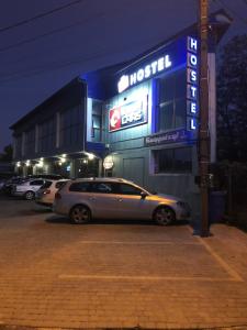 um carro estacionado em frente a um hotel à noite em VALIZA HOSTEL em Uzhhorod