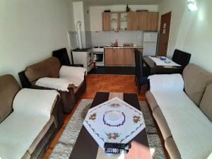 salon z kanapami i stołem oraz kuchnia w obiekcie Apartments Jovana w mieście Žabljak