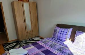 sypialnia z fioletowym łóżkiem i szafką w obiekcie Apartments Jovana w mieście Žabljak