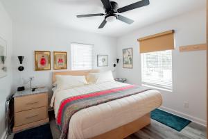 a bedroom with a bed and a ceiling fan at Folly Vacation Perfect Purple Palace Apt A in Folly Beach