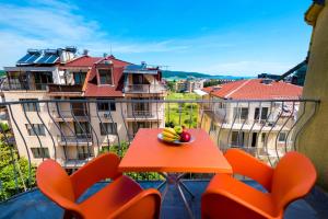 a table with fruit on it on a balcony with buildings at Guest House Zara in Primorsko