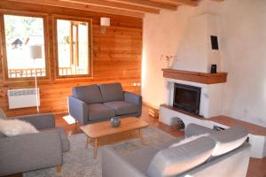 a living room with a couch and a fireplace at Chalet Le Murè hameau des Chazals Nevache Hautes Alpes in Névache